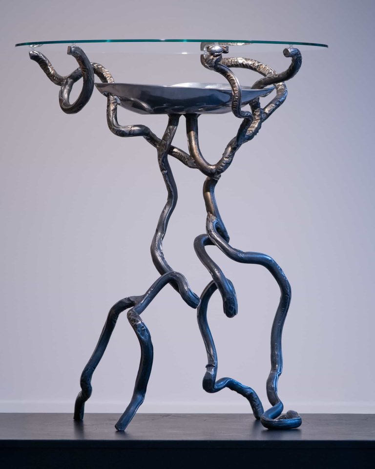 Pièce unique de KYMIA : une table d’art aux lignes torsadées et élégantes, mêlant force et légèreté grâce à son plateau en verre.