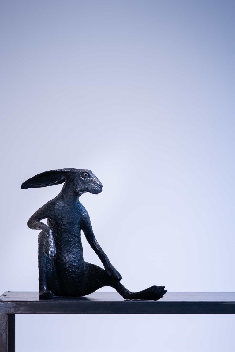 Oeuvre anthropomorphique représentant une posture méditative ou professorale. Cette sculpture attire le regard par son caractère et sa présence.