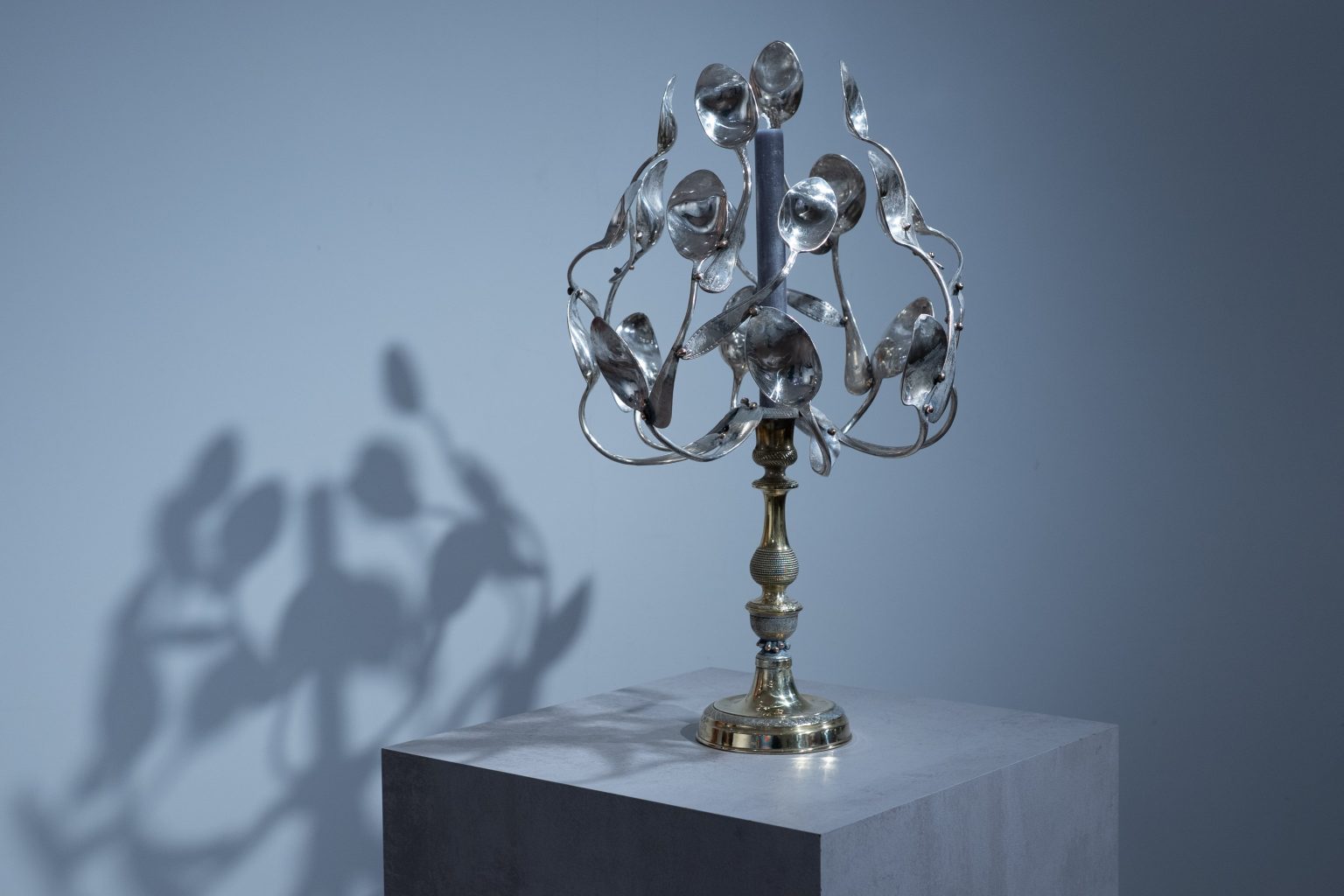Sculpture en argenterie et laiton, « Buisson ardent sur les dunes » déploie un buisson de cuillères comme des flammes figées dans la lumière, évoquant une apparition mystique au cœur d’un désert contemporain.